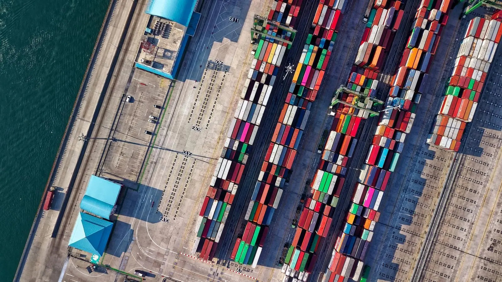 Aerial view of shipping containers laid out in rows across a terminal yard