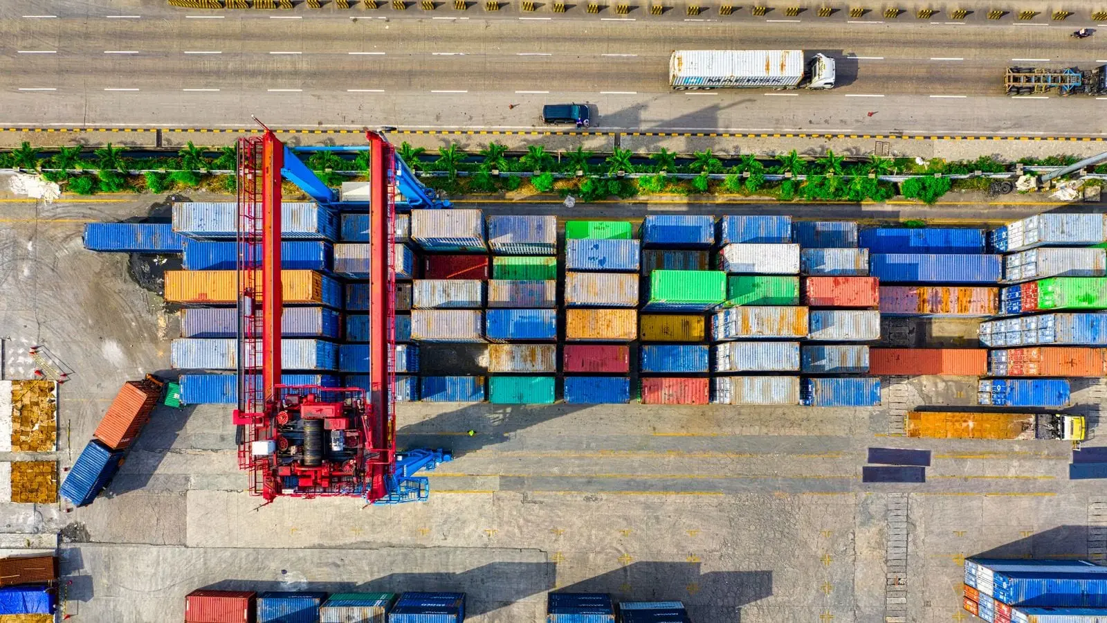 Aerial view of a container yard, with vessels berthed along the quay beyond