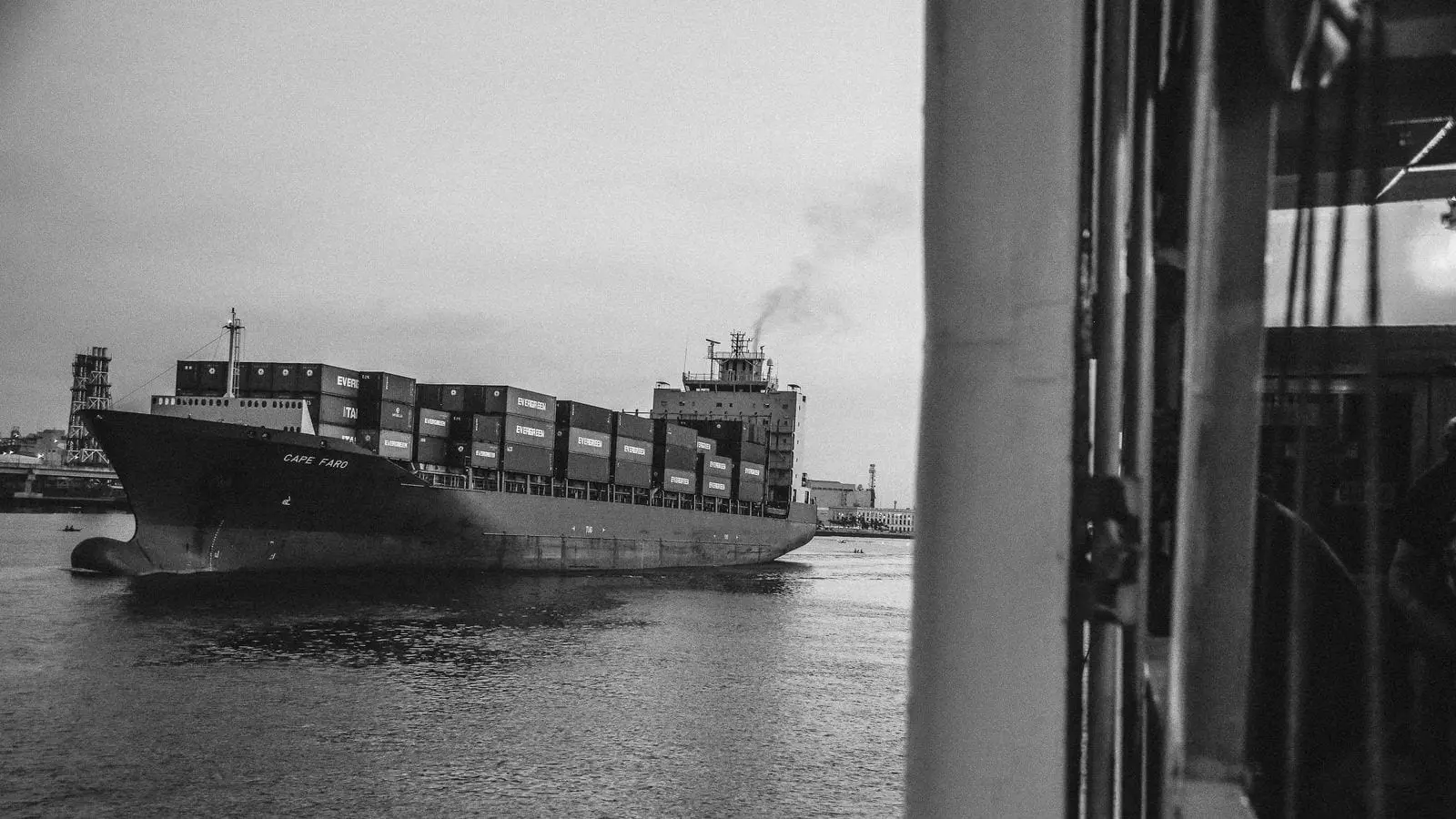 A container ship moving through a harbour under its own power