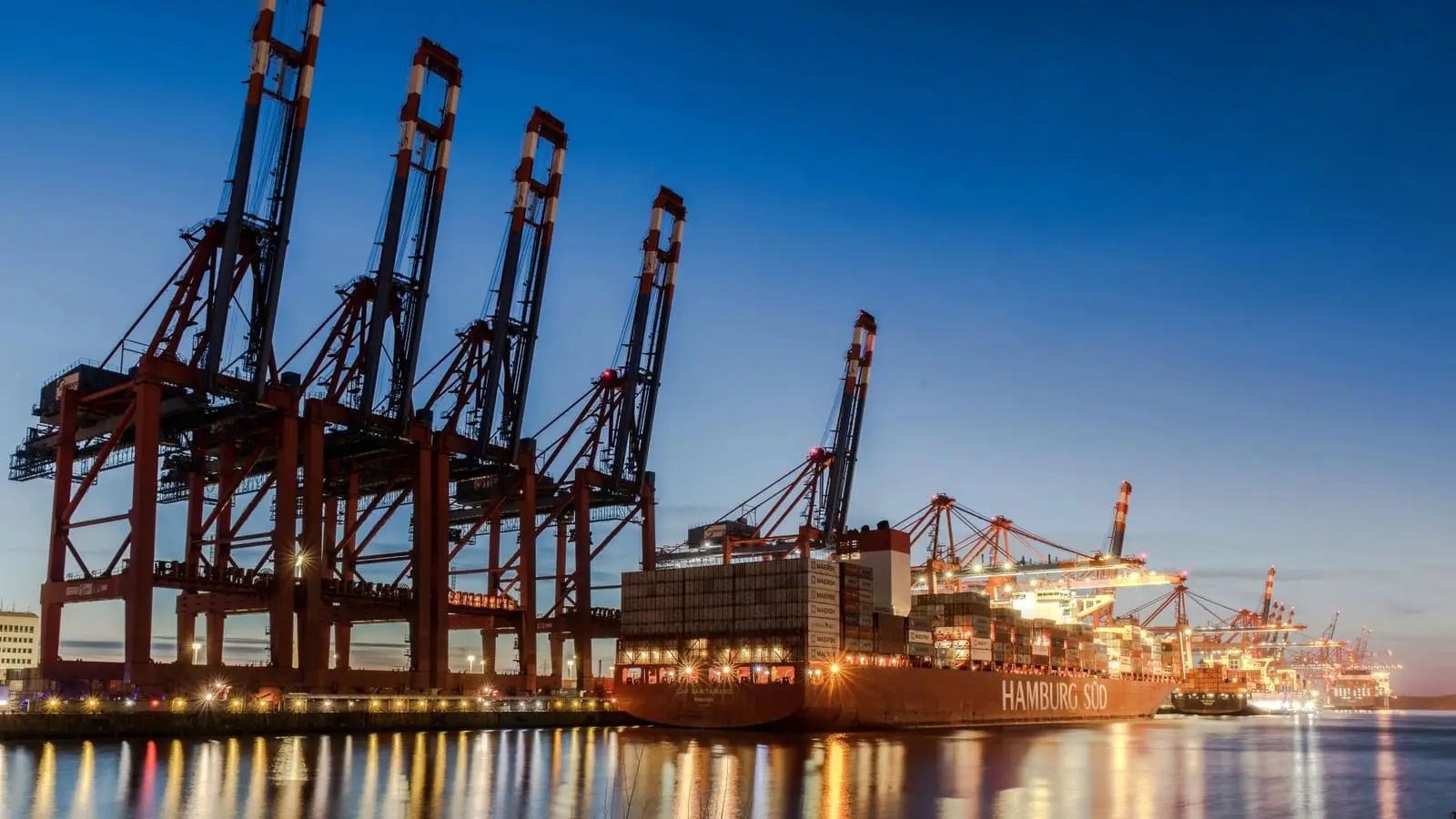 Ship-to-shore cranes working over a container vessel alongside a quay