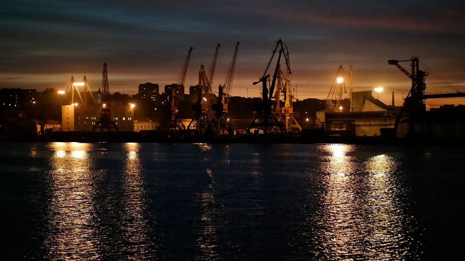Quayside cranes lit against the night sky at a working harbour