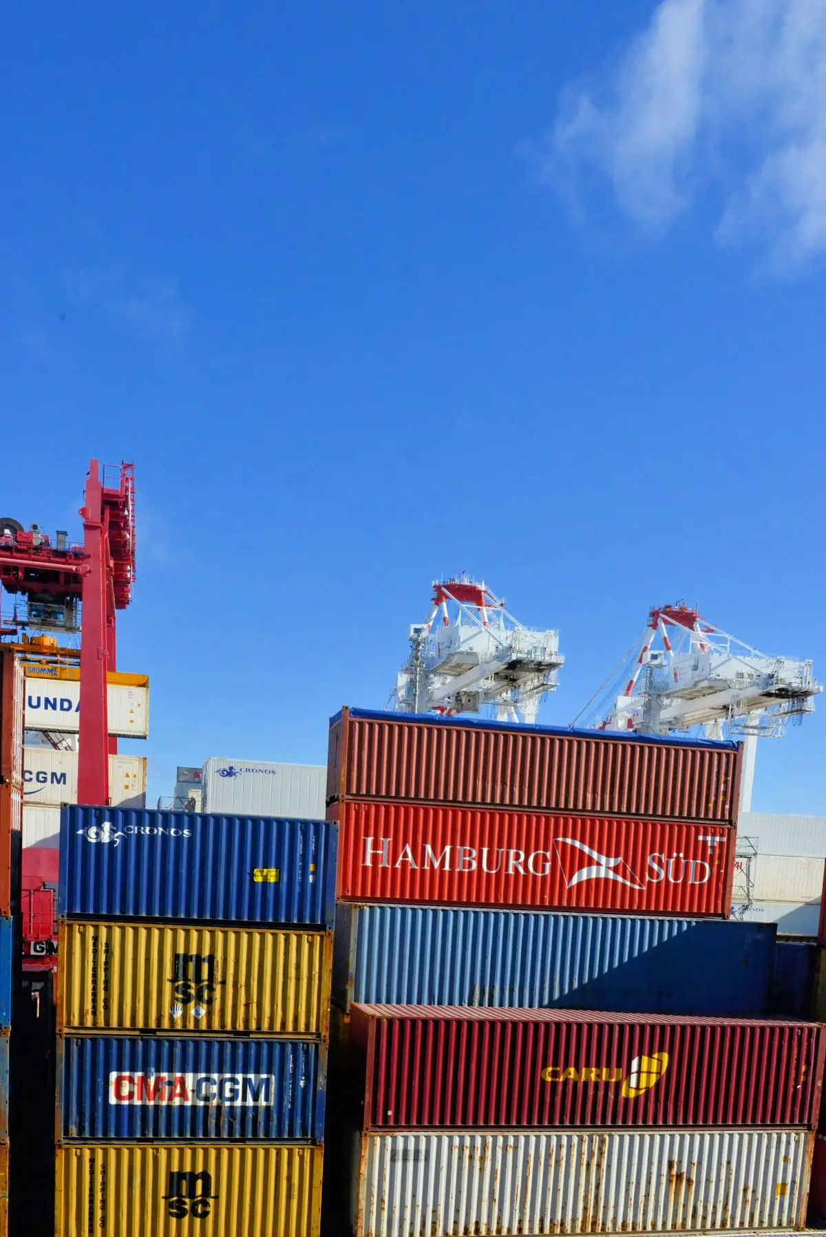 Cargo containers stacked at a shipping port under a clear sky