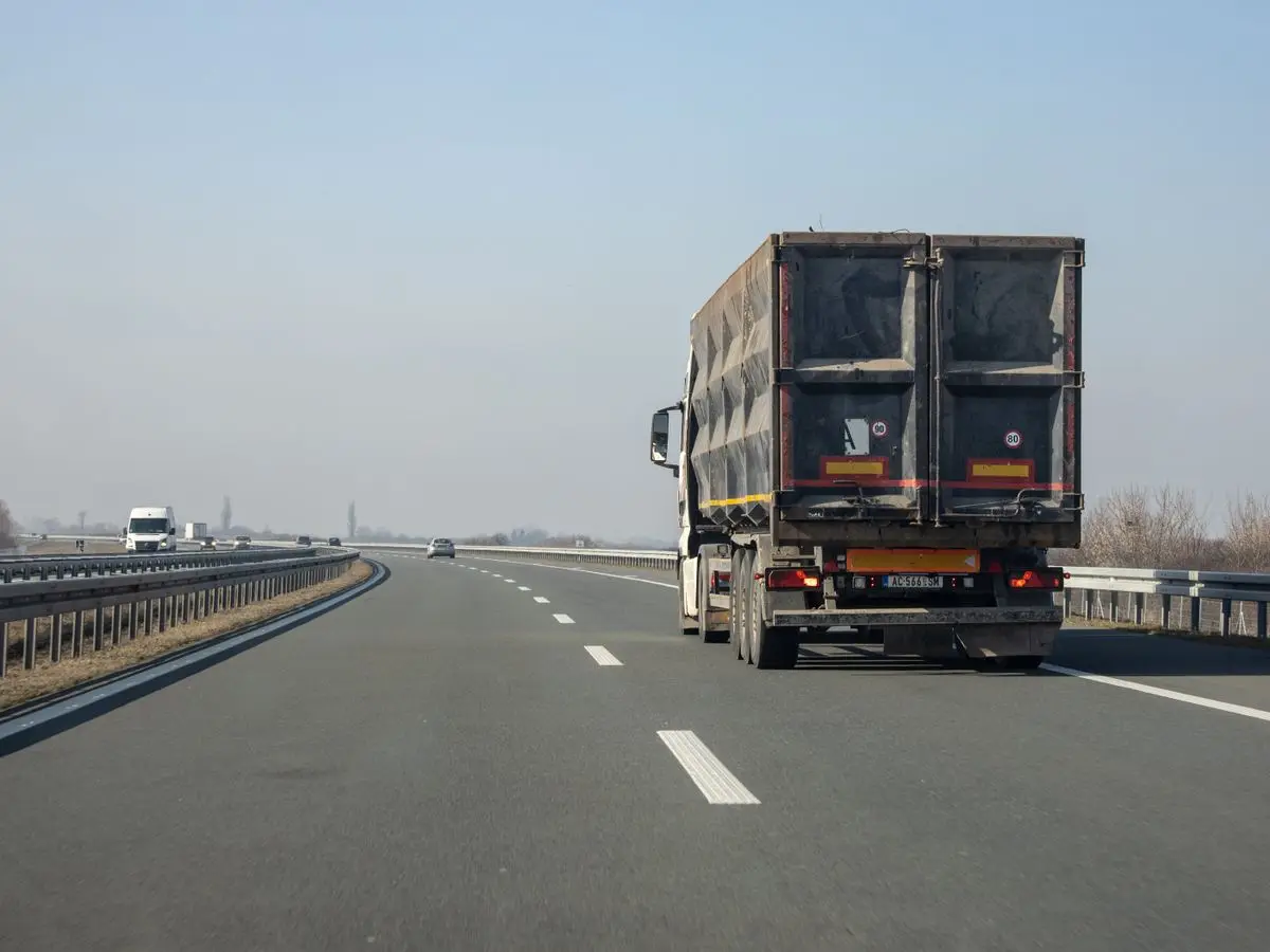 A cargo truck travelling along a highway for door-to-door delivery